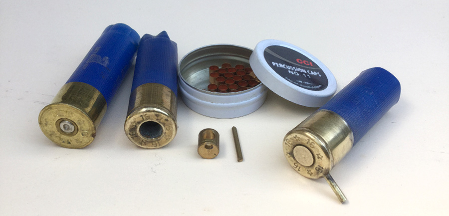 From left to right; a fired case, a sized and drilled case, caps, cap chamber and pin, loaded cartridge.